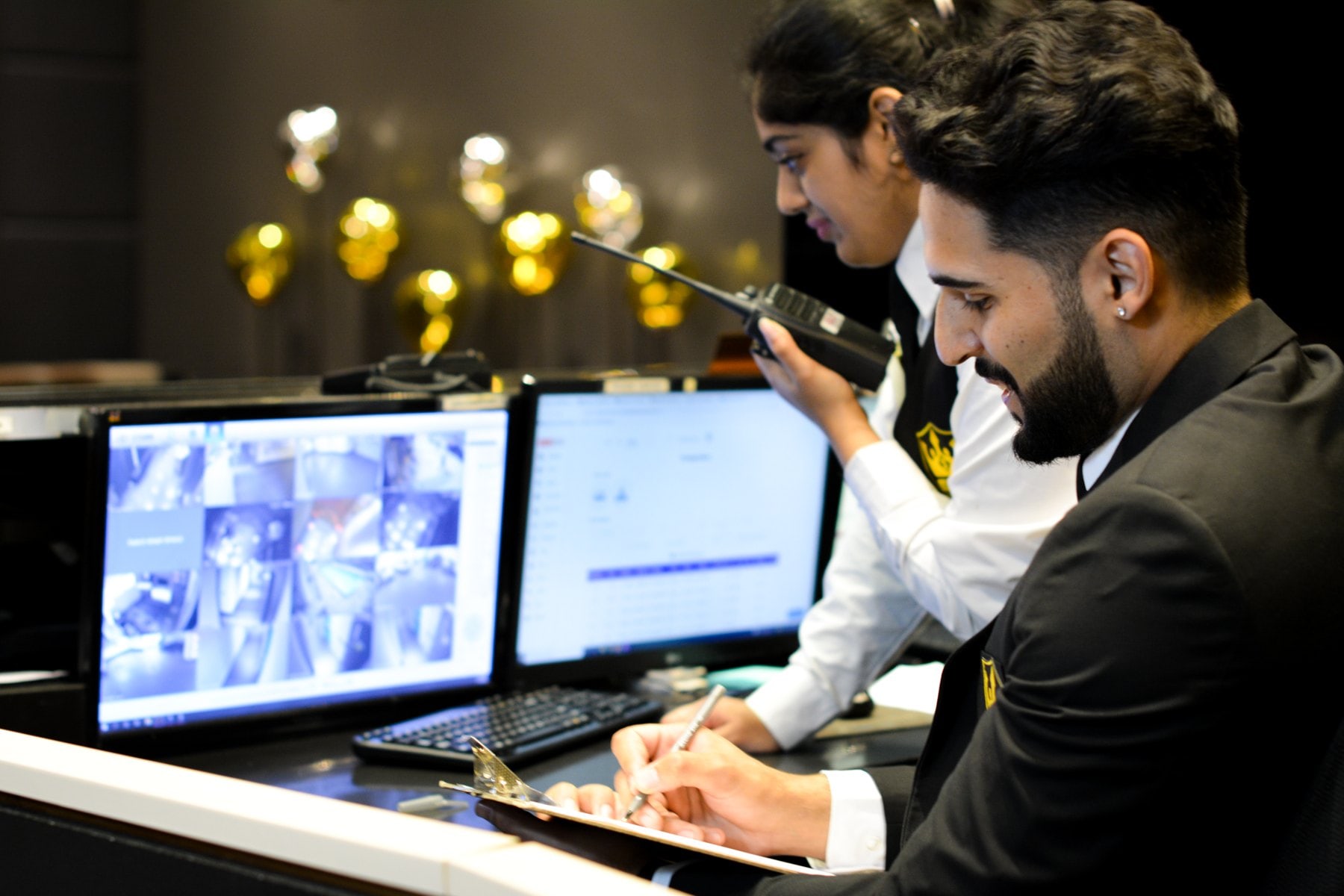 Officers at a concierge desk with CCTV monitors