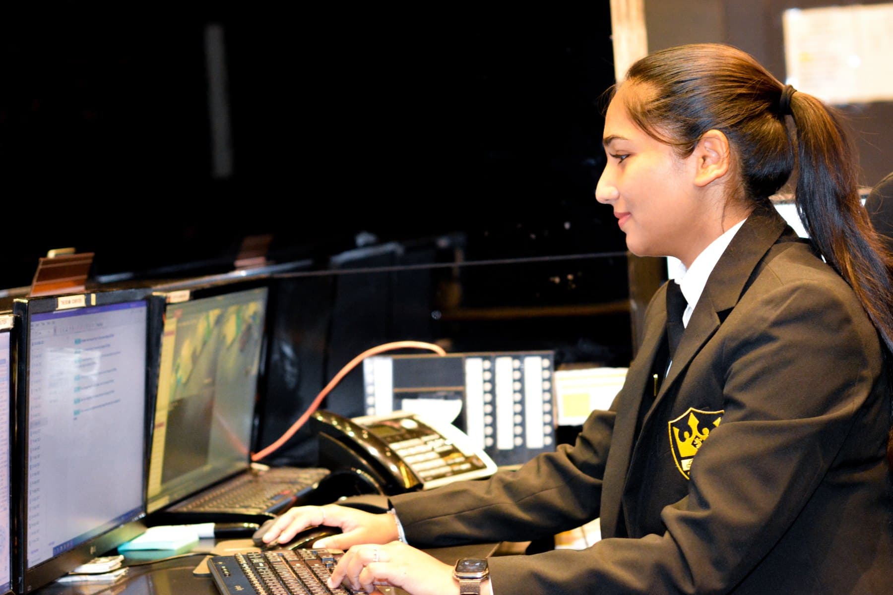Royal officer watching the CCTV monitors at a condominium desk